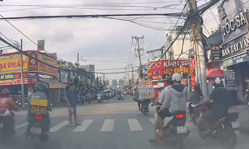 Người đi xe máy giúp người đi bộ qua đường