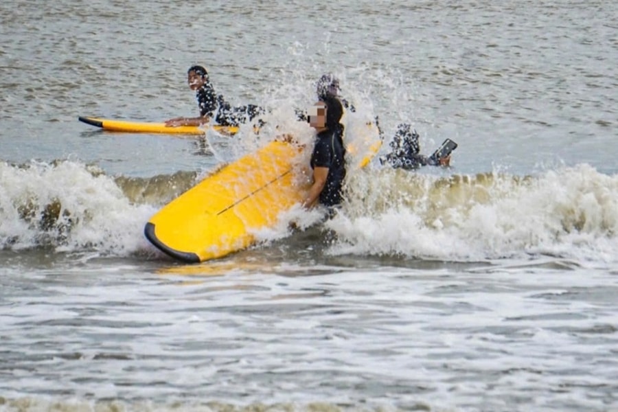 Du khách ra biển lướt sóng trước giờ bão Kalmaegi áp sát