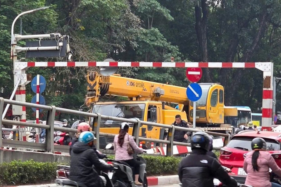 Xe cẩu húc đổ thanh chắn trên cầu vượt, rơi trúng hai xe máy