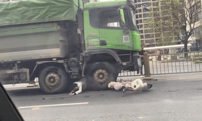 Người phụ nữ đi xe máy chui ra từ gầm xe ben